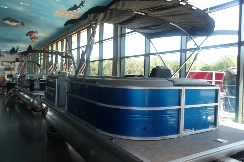 The Image of 2026 Sun Tracker Party Barge 20 DLX pontoon boat displayed indoors. - 1