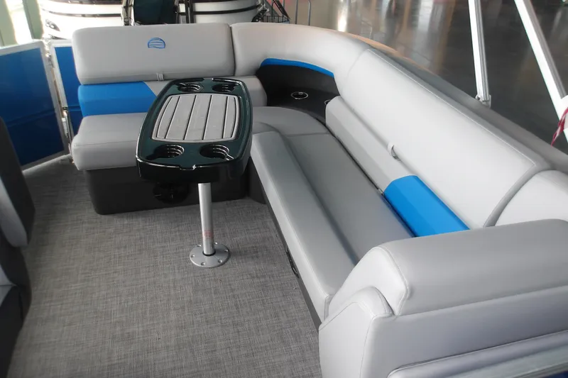 Slide: The Image of 2026 Sun Tracker Party Barge 20 DLX interior with gray and blue seating and table. - 10