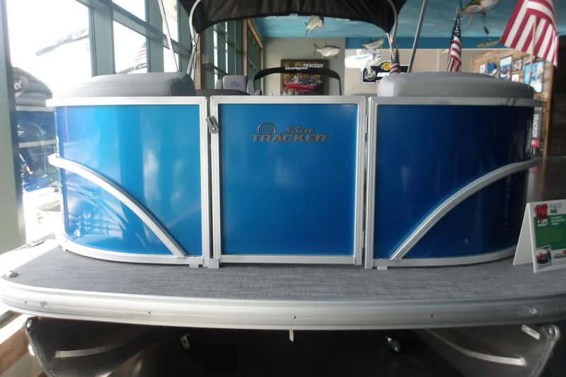 Slide: The Image of 2026 Sun Tracker Party Barge 20 DLX pontoon boat with blue exterior in showroom. - 7