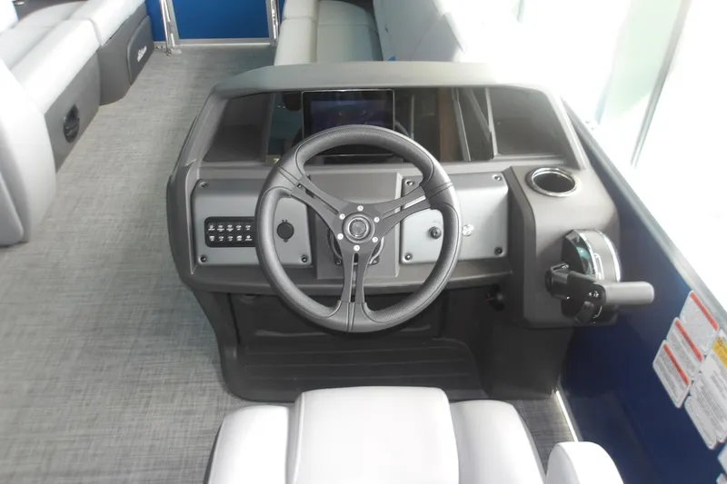 Slide: The Image of 2026 Sun Tracker Party Barge 20 DLX helm with steering wheel and control panel. - 12