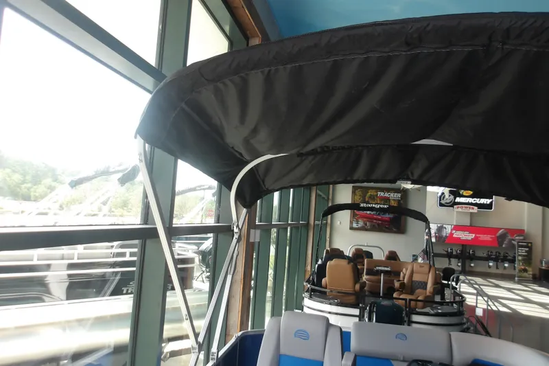 Slide: The Image of 2026 Sun Tracker Party Barge 20 DLX pontoon boat displayed indoors with canopy. - 17