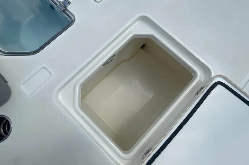 Slide: The Image of Open storage compartment on 2026 Mako 18 Pro Skiff boat deck. - 18