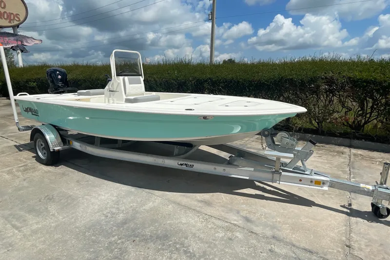 Slide: The Image of 2026 Mako 18 Pro Skiff boat on trailer, parked outdoors under a cloudy sky. - 5