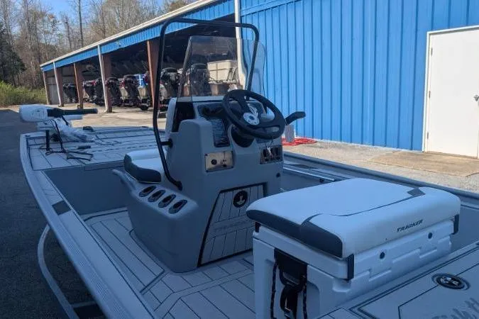 Slide: The Image of 2026 Tracker Bass Tracker Classic CC boat with steering console, parked near blue building. - 2