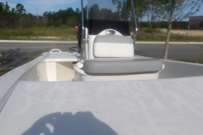Slide: The Image of 2026 Mako Pro Skiff 13 CC boat with seating, parked outdoors on a sunny day. - 15
