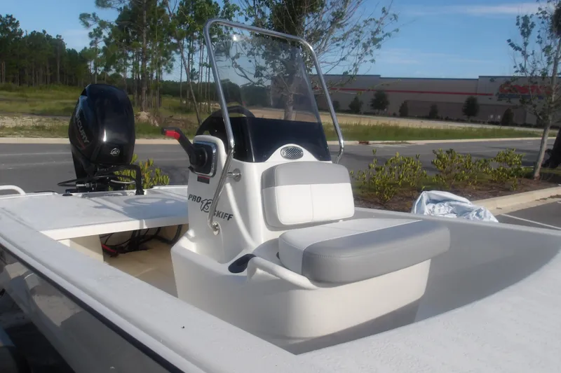 Slide: The Image of 2026 Mako Pro Skiff 13 CC boat with console and seating, parked outdoors. - 6