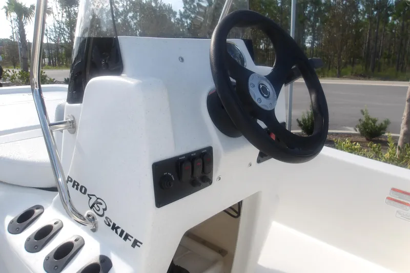Slide: The Image of 2026 Mako Pro Skiff 13 CC boat console with steering wheel and control panel. - 10