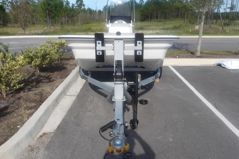 Slide: The Image of 2026 Mako Pro Skiff 13 CC on trailer in parking lot, surrounded by greenery. - 3