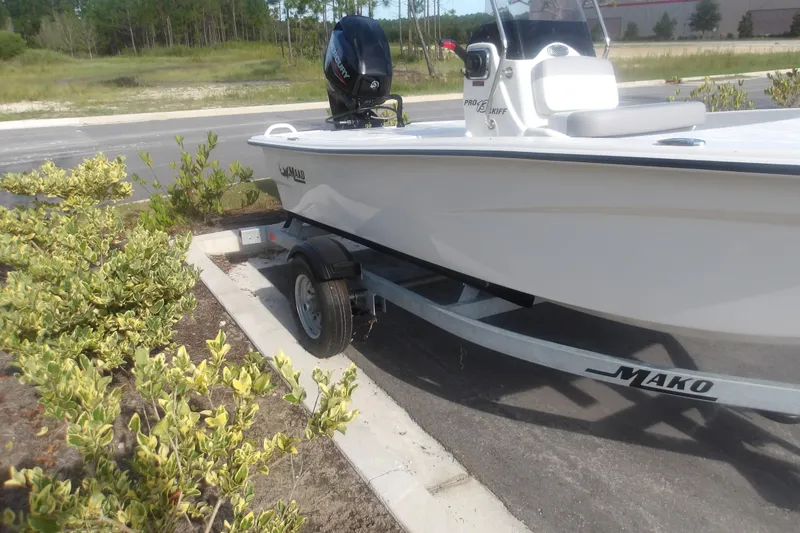 Slide: The Image of 2026 Mako Pro Skiff 13 CC boat on trailer, parked near greenery. - 5