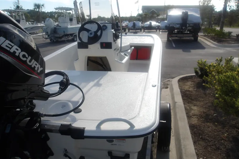 Slide: The Image of 2026 Mako Pro Skiff 13 CC boat with Mercury engine in a parking lot. - 8