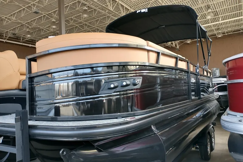 The Image of 2026 Regency 230 DL pontoon boat with sleek design and tan seating, displayed indoors. - 0