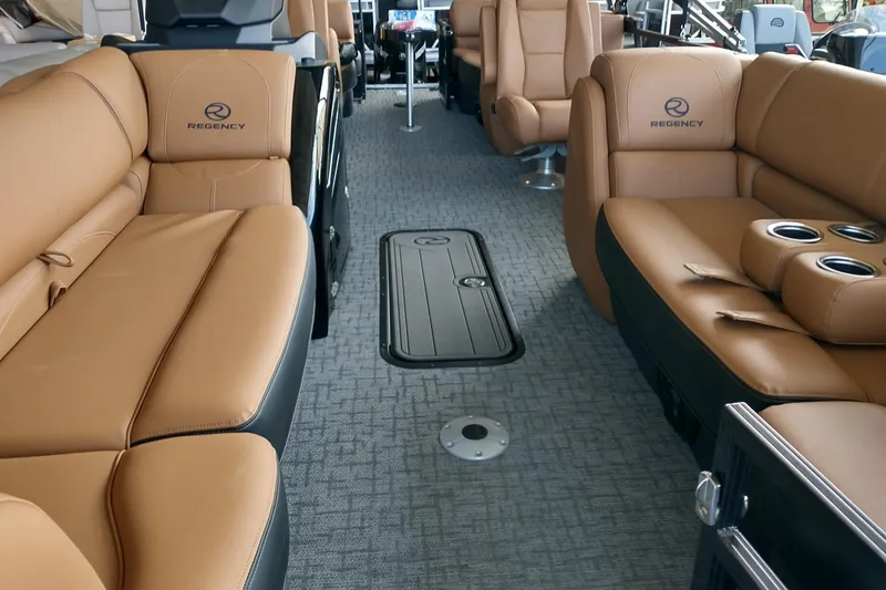 Slide: The Image of Luxurious interior of 2026 Regency 230 DL boat with tan leather seating and cup holders. - 2