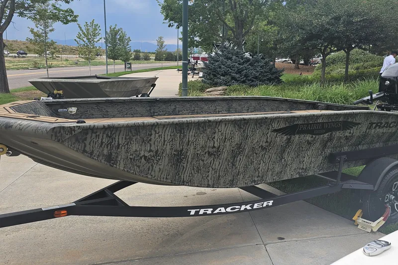The Image of 2026 Tracker Grizzly 1650 T Prairie Wings Edition boat on trailer, outdoors. - 0