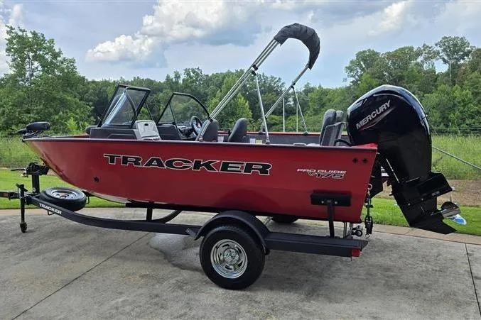 Slide: The Image of 2026 Tracker Pro Guide V-175 Combo boat on trailer, red exterior, parked outdoors. - 4