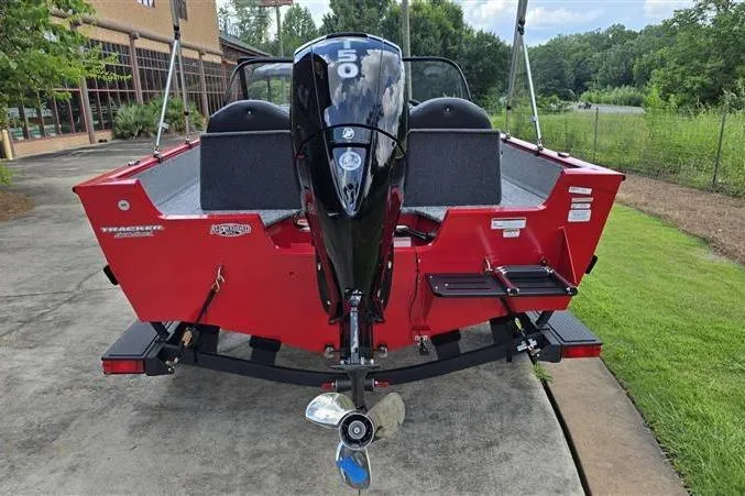 Slide: The Image of 2026 Tracker Pro Guide V-175 Combo boat, red exterior, rear view with motor, parked outdoors. - 5