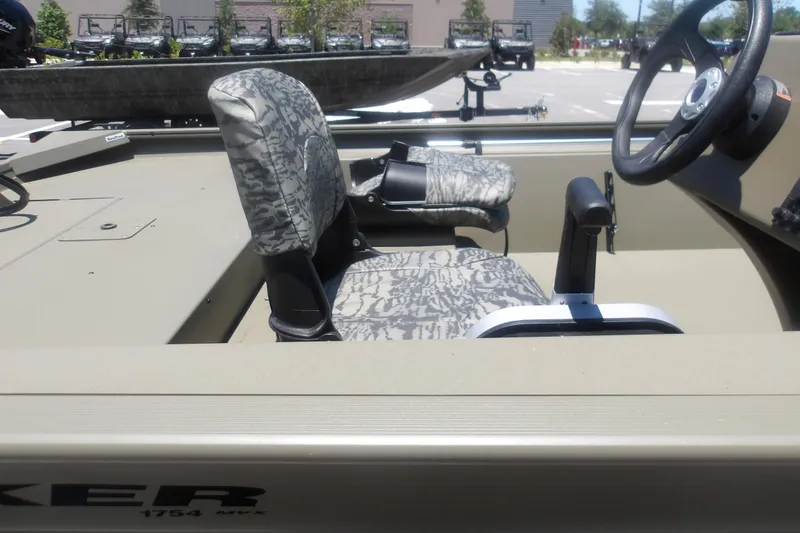 Slide: The Image of 2026 Tracker Grizzly 1754 SC boat interior with camo seats and steering wheel. - 9