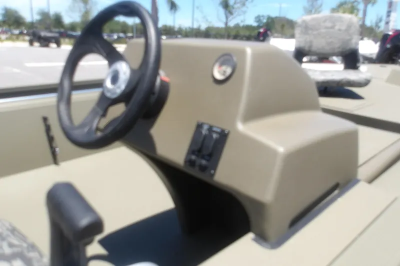 Slide: The Image of 2026 Tracker Grizzly 1754 SC boat console with steering wheel and controls. - 10