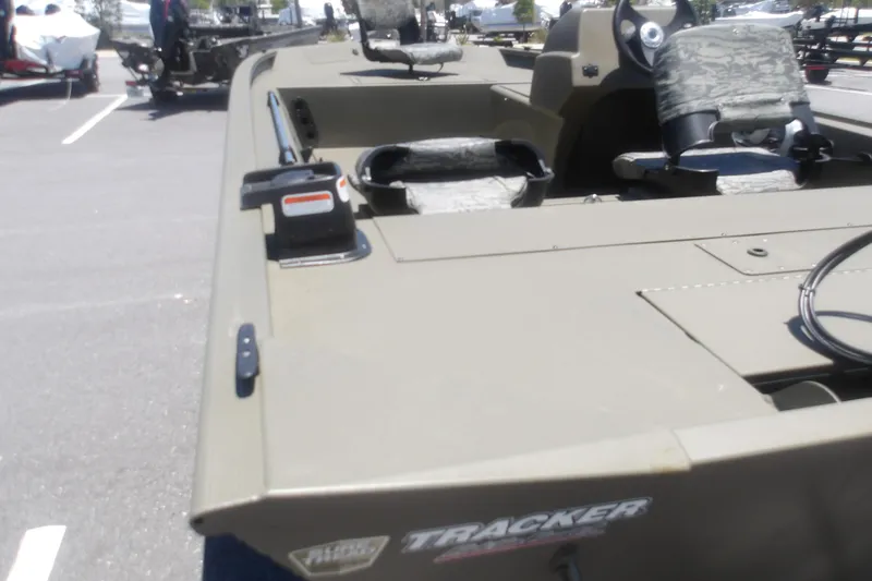 Slide: The Image of 2026 Tracker Grizzly 1754 SC boat with camouflage seats in a parking lot. - 7