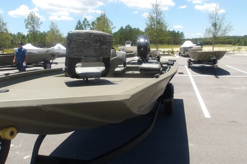 Slide: The Image of 2026 Tracker Grizzly 1754 SC boat in parking lot under clear sky. - 13