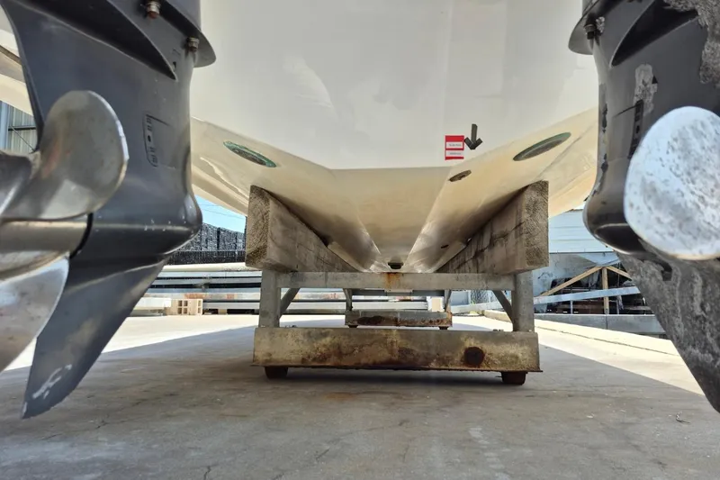 Slide: The Image of 2008 Robalo R305 Walkaround boat on a stand, showing dual propellers and hull underside. - 6