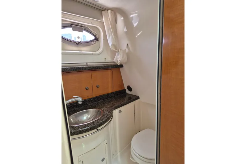 Slide: The Image of 2008 Robalo R305 Walkaround boat bathroom with sink, toilet, and porthole window. - 19