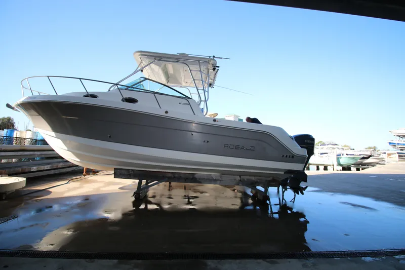 Slide: The Image of 2008 Robalo R305 Walkaround boat on dry dock, side view under clear sky. - 3