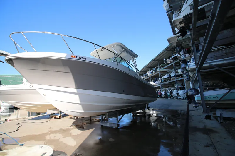 Slide: The Image of 2008 Robalo R305 Walkaround boat in storage, side view under clear blue sky. - 4