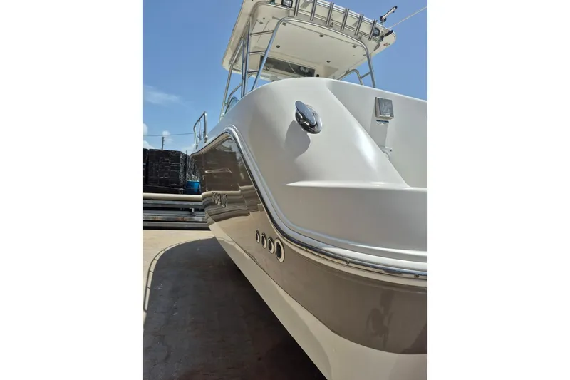 Slide: The Image of 2008 Robalo R305 Walkaround boat, sleek design, docked under clear blue sky. - 36