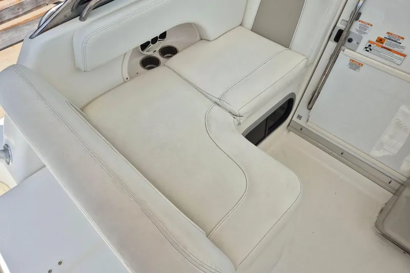 Slide: The Image of 2008 Robalo R305 Walkaround boat interior with white cushioned seating and cup holders. - 9