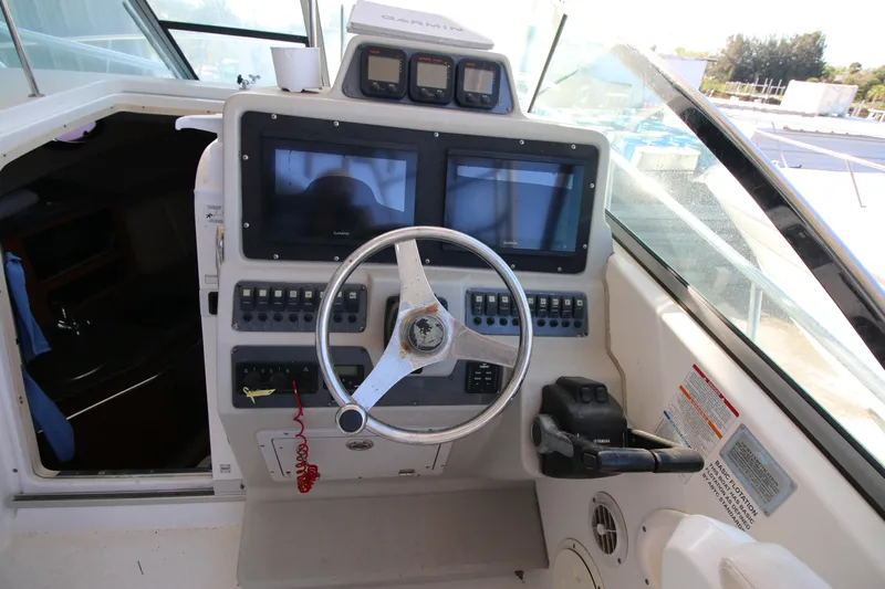 Slide: The Image of 2008 Robalo R305 Walkaround helm with dual Garmin displays and steering wheel. - 9