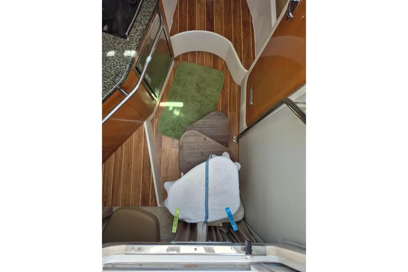 Slide: The Image of Interior of 2008 Robalo R305 Walkaround boat with wooden flooring and compact kitchen area. - 14