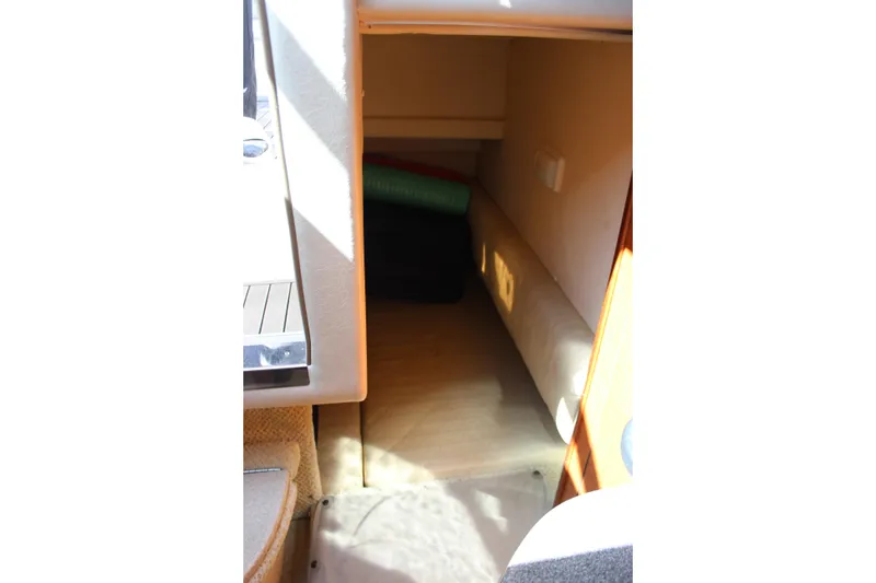 Slide: The Image of Interior cabin of 2006 Sea Ray Sundancer 260, featuring cozy seating and storage space. - 23