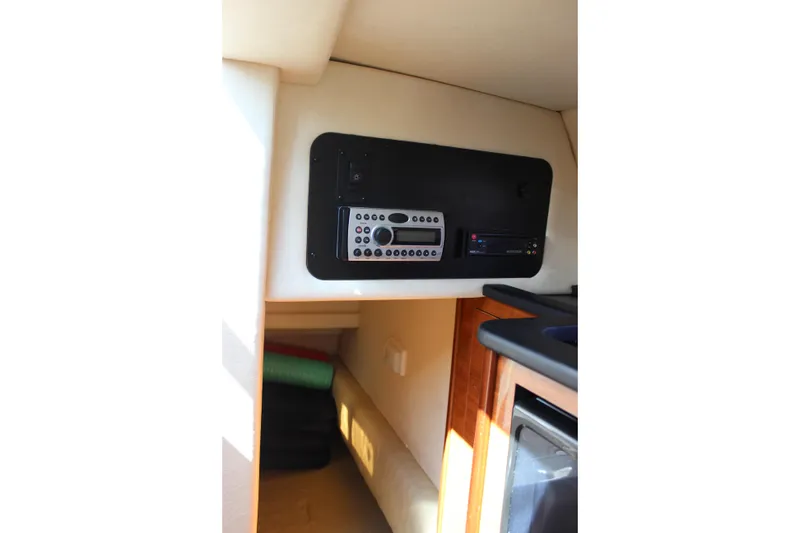 Slide: The Image of Interior of 2006 Sea Ray Sundancer 260 with control panel and cozy cabin space. - 24