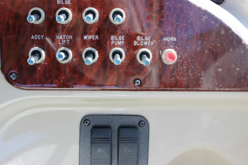 Slide: The Image of Control panel of a 2006 Sea Ray Sundancer 260 boat with switches and buttons. - 39
