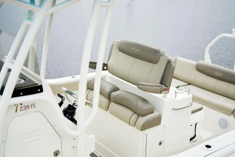 Slide: The Image of 2026 Key West 239 FS boat interior with beige seating and steering console. - 2