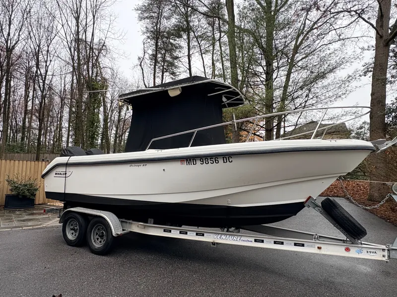 Slide: The Image of 1999 Boston Whaler 230 Outrage on trailer in wooded area. - 11