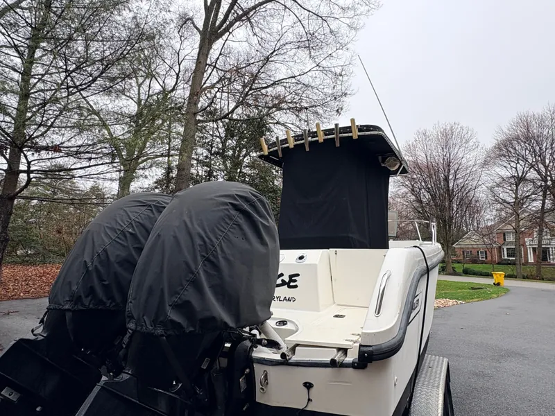 Slide: The Image of 1999 Boston Whaler 230 Outrage with covered engines outdoors. - 14