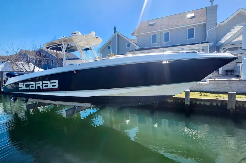 The Image of 2014 Wellcraft 35 Scarab Sport boat docked near waterfront homes. - 0