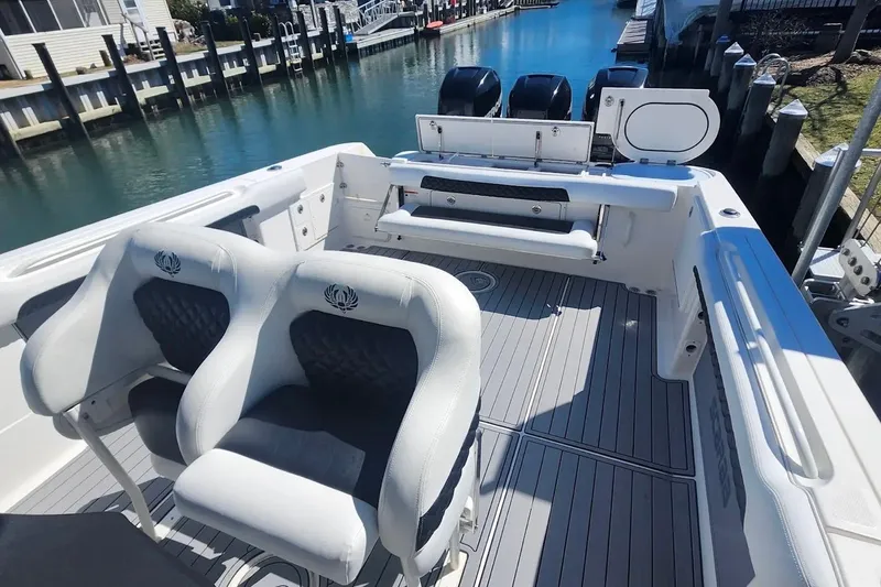 Slide: The Image of 2014 Wellcraft 35 Scarab Sport boat interior with seating and dock view. - 11