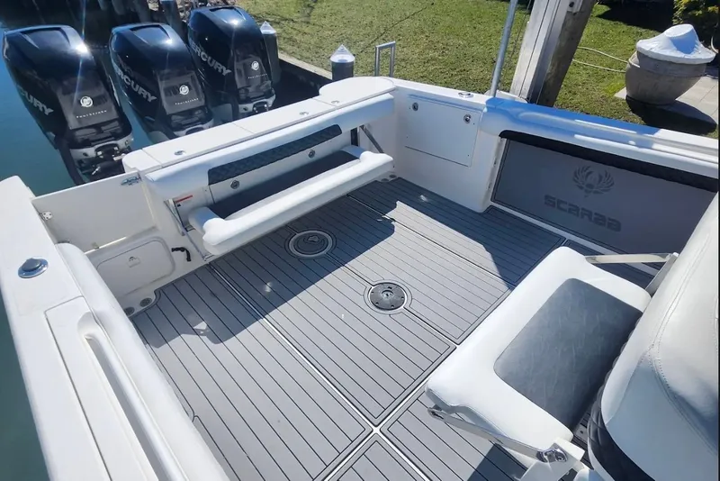 Slide: The Image of 2014 Wellcraft 35 Scarab Sport boat deck with Mercury engines, featuring seating and storage. - 13