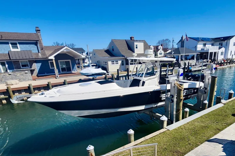 Slide: The Image of 2014 Wellcraft 35 Scarab Sport boat docked in a scenic waterfront neighborhood. - 28