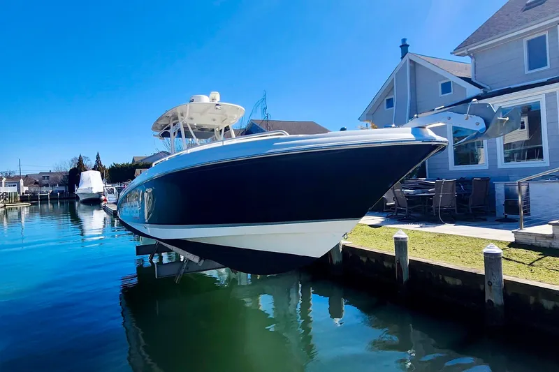 Slide: The Image of 2014 Wellcraft 35 Scarab Sport boat docked by waterfront home. - 29
