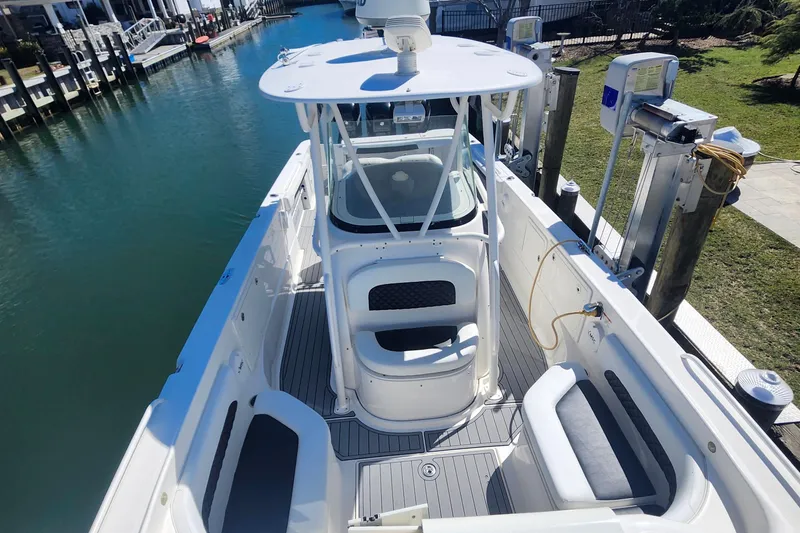 Slide: The Image of 2014 Wellcraft 35 Scarab Sport boat docked, featuring spacious deck and seating. - 4