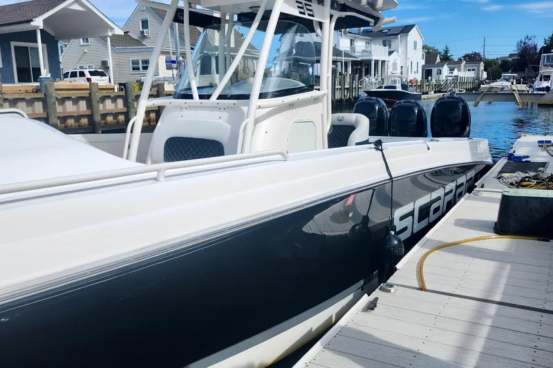 Slide: The Image of 2014 Wellcraft 35 Scarab Sport boat docked at a marina, side view. - 5