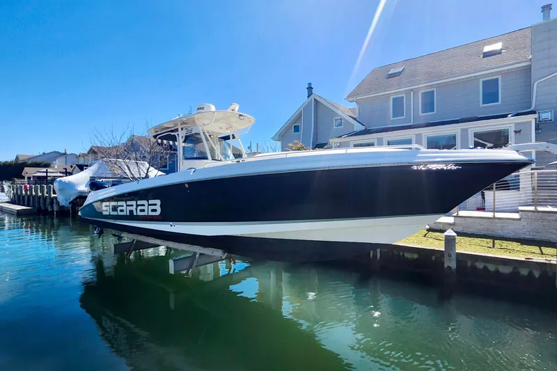 Slide: The Image of 2014 Wellcraft 35 Scarab Sport boat docked by waterfront home. - 6