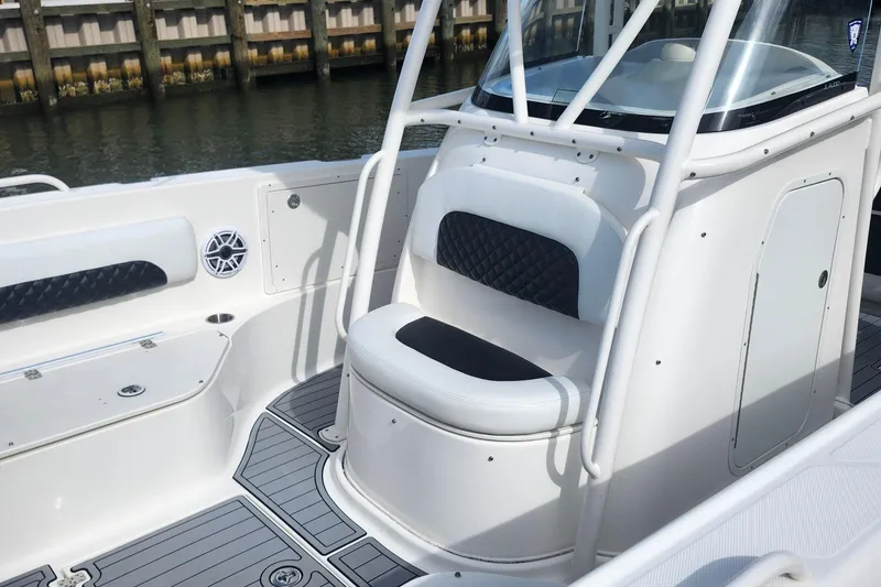 Slide: The Image of 2014 Wellcraft 35 Scarab Sport boat interior with seating and speaker, dockside view. - 7