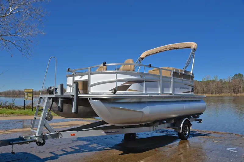 Slide: The Image of 2023 Starcraft EX 18 F pontoon boat on trailer by a lake. - 10