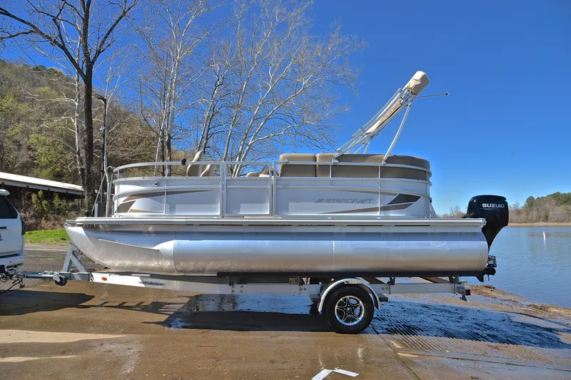 Slide: The Image of 2023 Starcraft EX 18 F pontoon boat on trailer by a lake. - 11