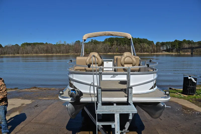 Slide: The Image of 2023 Starcraft EX 18 F pontoon boat on a trailer by a lake. - 17