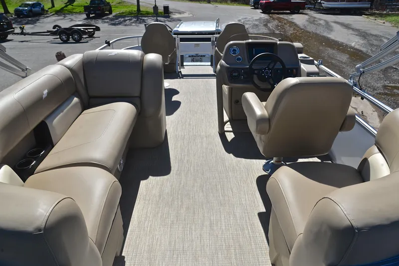Slide: The Image of 2023 Starcraft EX 18 F pontoon boat interior with beige seating and steering console. - 18